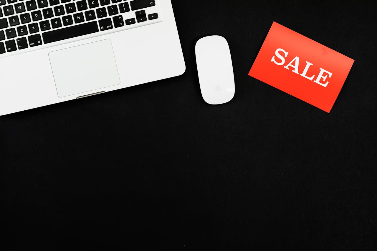 Texter Preis Ein Laptop, eine Maus und ein Sale-Schild. Der Texter Preis ist reduziert.